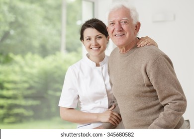 Young Nurse Taking Care Of Old Sick Man