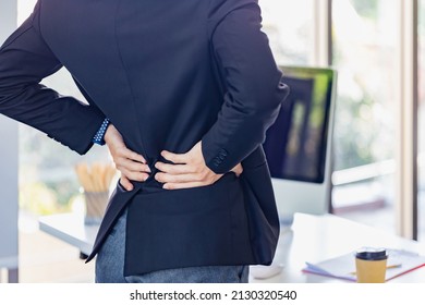 Young Office Man Feeling Backpain By Office Syndrome, People With Body-muscles Problem, Young Man Suffering From Backache In Office, Healthcare And Medical Concepts