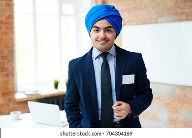 Young Office Worker In Suit And Blue Turban Standing In Front Of Camera