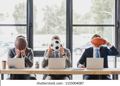 young office workers holding balls while working with laptops in office   - Powered by Shutterstock