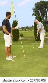 Young And Old Golfer Playing Together.