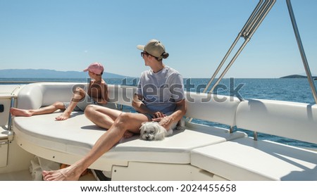 Young and older brothers spending time together on motor yacht. Rest on a yacht