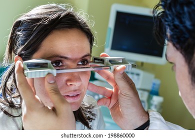 A Young Ophthalmologist Using An Exophthalmometer, An Instrument Used For Measuring The Degree Of Forward Displacement Of The Eye In Exophthalmos