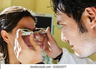 A Young Ophthalmologist Using An Exophthalmometer, An Instrument Used For Measuring The Degree Of Forward Displacement Of The Eye In Exophthalmos