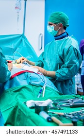 Young Orthopedic Surgeon With Surgical Mask And Sterile Uniform Near His Patient, Right Before Starting The Surgery In The Operating Room.