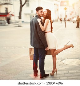 Young Outdoor Fashion Portrait Of Beautiful Couple Kissing On The Street