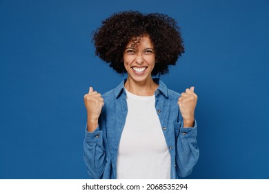 Young Overjoyed Excited Happy Black Woman 20s Wear Casual Clothes Shirt White T-shirt Do Winner Gesture Clench Fist Isolated On Plain Dark Blue Background Studio Portrait. People Lifestyle Concept.