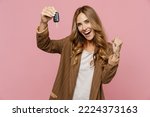 Young overjoyed fun happy successful employee business woman 30s she wear casual brown classic jacket hold car key fob keyless system do winner gesture isolated on plain pastel light pink background
