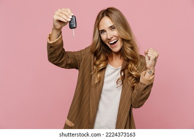 Young overjoyed fun happy successful employee business woman 30s she wear casual brown classic jacket hold car key fob keyless system do winner gesture isolated on plain pastel light pink background - Powered by Shutterstock