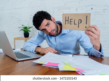 Young overwhelmed entrepreneur needing help paying off debts and bills in Small business financial problems. Worried desperate young man feeling stressed working through finances at home office.