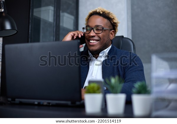 Young owner of the company calls the financial\
manager, happily looks into his laptop, rejoicing at the large\
profit of his company. Businessman signs a new contract with his\
partner on a mobile phone