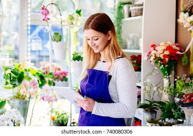 Young Owner Of Flower Shop Taking Orders Online By Tablet. Small Business