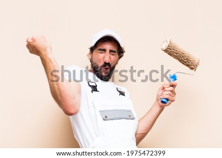 young painter bearded man celebrating his success and holding a 