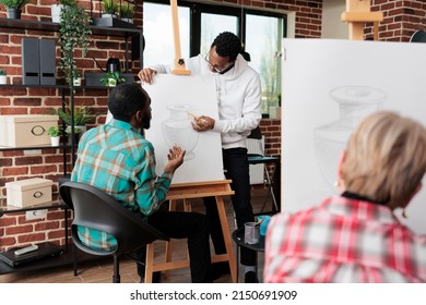 Young Painter Teacher Helping Student With Drawing Process During Art Class In Community Center. Diverse Students Sketching Vase Model Using Grahpic Pencil Earning Skill For Personal Personal