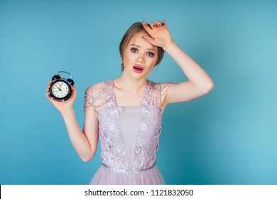 young and panic beautiful woman bride with makeup in white wedding dress holds an alarm clock in hand and screams . concept of being late for a wedding ceremony ( date ) . I am late to my wedding