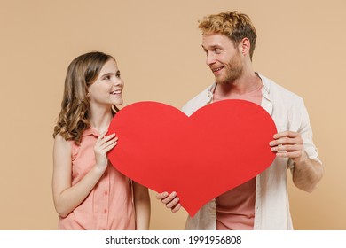 Young Parent Man With Child Teen Girl In Casual Clothes Daddy Kid Daughter Hold Huge Red Heart Mock Up Look To Each Other Isolated On Beige Background Studio Portrait. Father's Day Love Family Concept