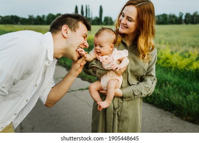 Young parents hug and kiss their newborn daughter in nature. - Powered by Shutterstock