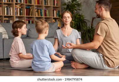 Young parents meditating with kids at home. beautiful family father, mother and two kids with closed eyes practicing yoga while sitting in circle in lotus pose - Powered by Shutterstock