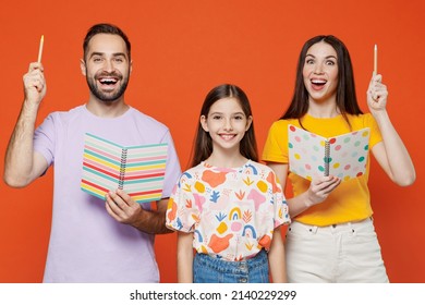 Young Parents Mom Dad With Child Kid Daughter Teen Girl In Basic T-shirts Help Schoolgirl To Do Homework Hold Exercisebook Isolated On Yellow Background Studio Portrait. Family Day Parenthood Concept.