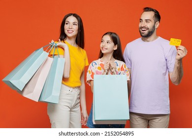 Young Parents Mom Dad With Child Kid Daughter Teen Girl In Basic T-shirts Hold Credit Bank Card Package Bags With Purchases After Shopping Look Aside Isolated On Yellow Background. Family Day Concept.