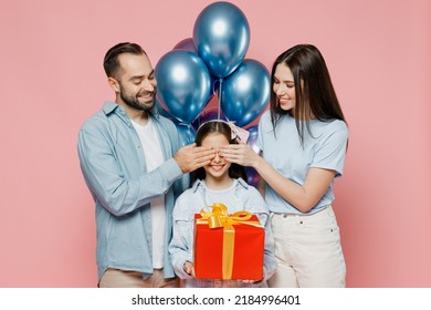 Young Parents Mom Dad With Child Kid Daughter Teen Girl In Blue Clothes Celebrating Birthday Party Hold Bunch Air Inflated Balloons Red Present Box Cover Eyes Isolated On Plain Pastel Pink Background.