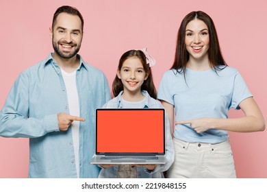 Young Parents Mom Dad With Child Kid Daughter Teen Girl In Blue Clothes Hold Use Point Finger On Laptop Pc Computer Blank Screen Workspace Area Isolated On Plain Pink Background. Family Day Concept.