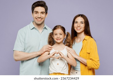 Young parents mom dad with child kid daughter girl 6 year old wear blue yellow casual clothes show shape heart with hands heart-shape sign, hug isolated on plain purple background. Family day concept - Shutterstock ID 2367234429