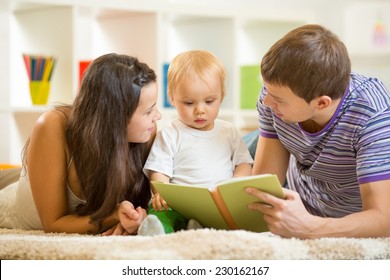 Young Parents Mom And Dad Reading Children Book To Baby Son