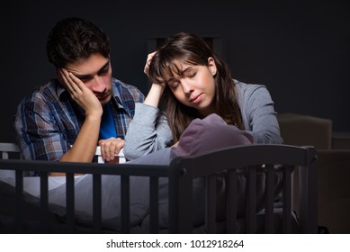 La nuit, les jeunes parents somnolent avec un nouveau-né