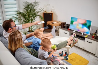 Young Parents Watching TV With Baby Boys.