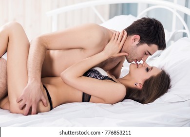 Young passionate couple making love in bed.