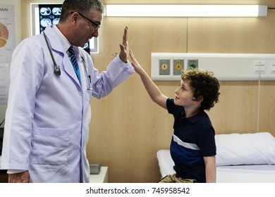 Young Patient Boy Giving A Doctor Hi Five