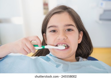 Young patient brushing her teeth in dental clinic - Shutterstock ID 245558002