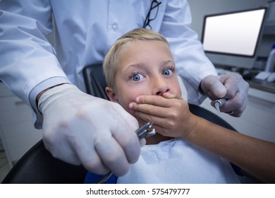 Young patient scared during a dental check-up at clinic - Powered by Shutterstock