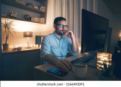 Young Pensive Man Working Remotely From Home At Night. 