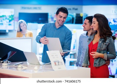 Young People Buying And Testing Latest Laptop