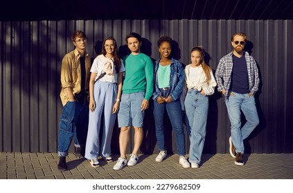 Young people in casual everyday clothes leaning on street wall. Group portrait of six happy relaxed beautiful multiethnic fashion models posing in shirts, tees, jumpers, jeans and denim jackets - Shutterstock ID 2279682509