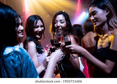 Young People Celebrating A Party, Drink And Dance . Group Of Friend Toasting Drinks While Having Fun At The Disco Club At Night . Friendship And Nightlife Concept .