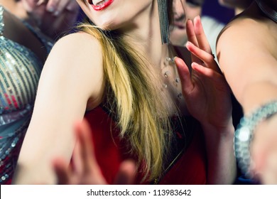 Young people dancing in club or disco and have party; the girls and boys, friends, having fun