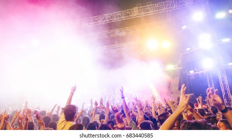 Young People Dancing And Having Fun In Summer Festival Party Outdoor - Crowd Celebrating Fest Concert Event With Famous Artist - Soft Focus On Left Hands Up - Soft Saturated Filter