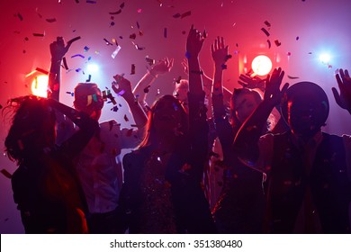 Молодые люди танцуют в ночном клубе