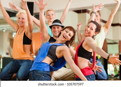 young people dancing in a studio or gym doing sports or practicing a dance number - Powered by Shutterstock