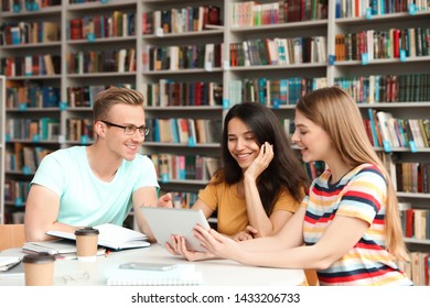 Young People Discussing Group Project At Table In Library