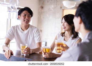 Young People Drinking Alcohol At A Bar