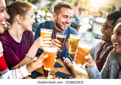 Young people drinking beer pints at brewery bar garden - Genuine beverage life style concept with guys and girls sharing happy hour together at open air pub dehor - Warm sunset backlight filter - Shutterstock ID 2258623431