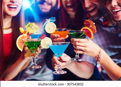 Young people drinking cocktails at nightclub