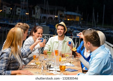 Young People Drinking Shots At Outside Bar Night Out