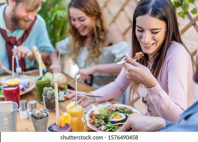 Young people eating brunch and drinking smoothie bowl at vintage bar - Happy people having a healthy lunch and chatting in trendy restaurant - Food trends and love concept - Focus on right girl face - Powered by Shutterstock