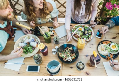 Young people eating brunch and drinking smoothie bowl at eco plastic- free cafeteria - Happy people having a healthy lunch and chatting together - Food trends concept - Focus on table dishes - Powered by Shutterstock