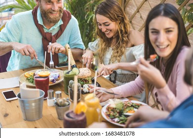 Young People Eating Brunch And Drinking Smoothies Bowl With In Eco Bar Restaurant - Healthy Lifestyle, Food Trends Concept - Focus On Left Couple Faces